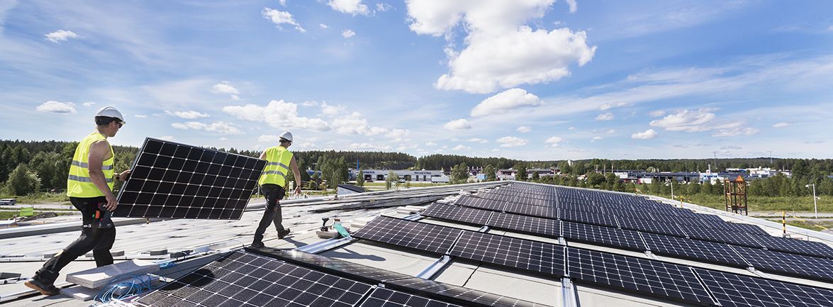 Montörer installerar solceller på ett tak - investera i solpaneler till din verksamhet